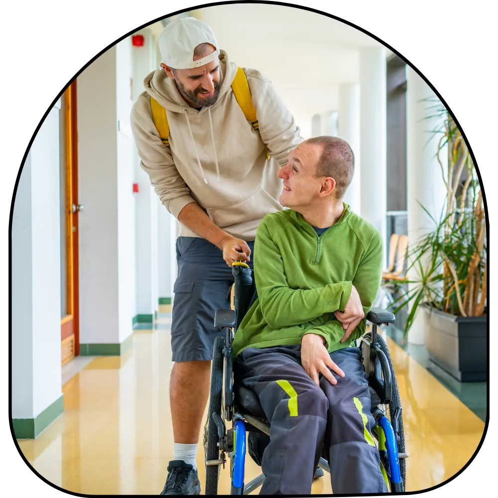 Disabled man in wheelchair looking up at support worker